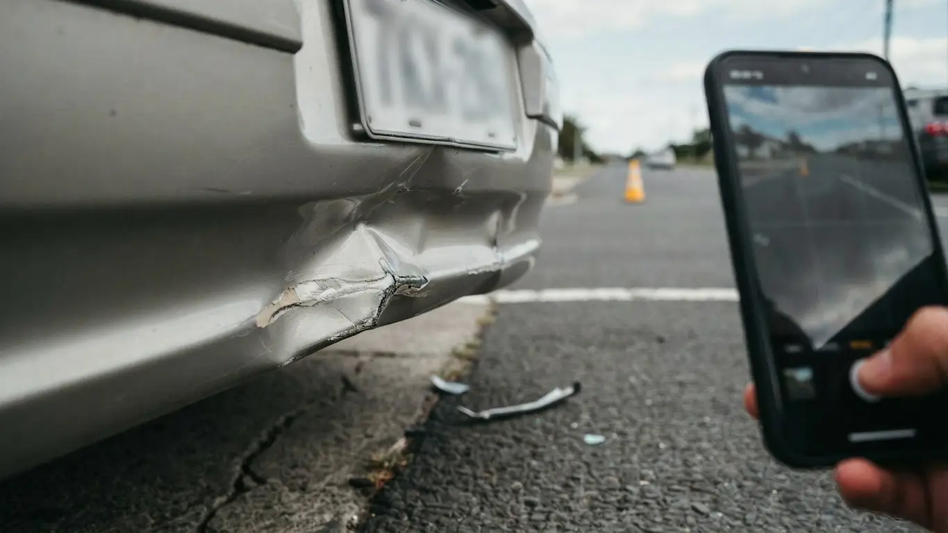 Smartphone taking photos to document the scene before you leave after a car accident